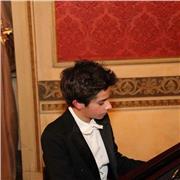 Ragazzo giovane impartisce lezioni di pianoforte per coloro che volessero iniziare, Torino